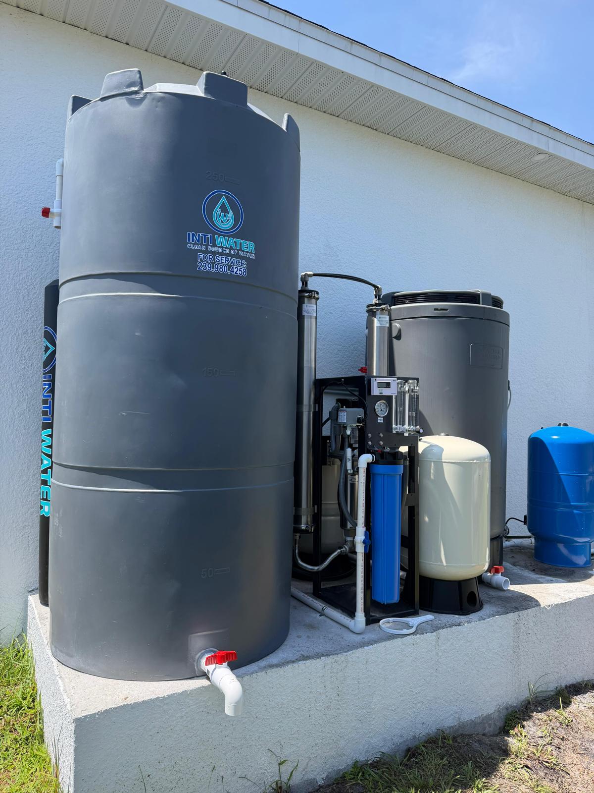 Inti Water whole-home reverse osmosis system installed on a concrete pad in Southwest Florida — storage tank, dual-membrane RO unit, pressure tanks and control panel.