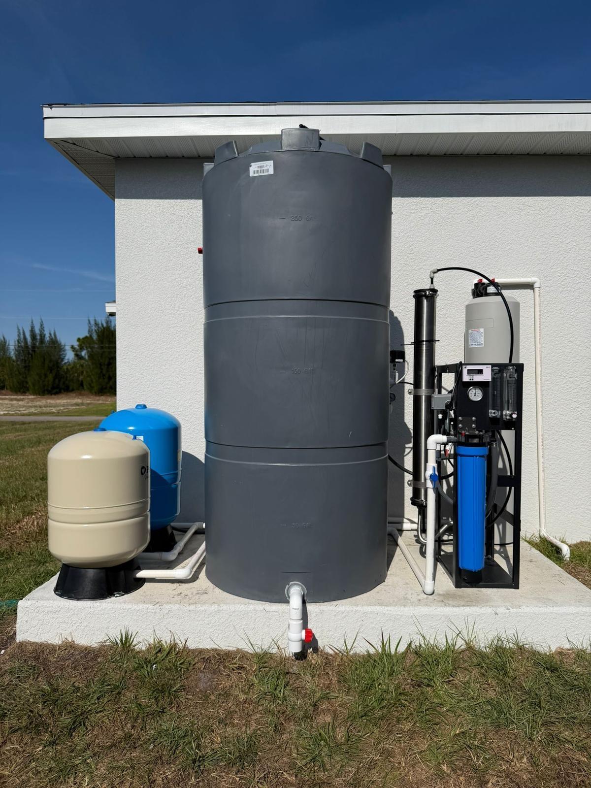 Inti Water whole-home reverse osmosis system installed on a concrete pad in Southwest Florida — storage tank, dual-membrane RO unit, pressure tanks and control panel.