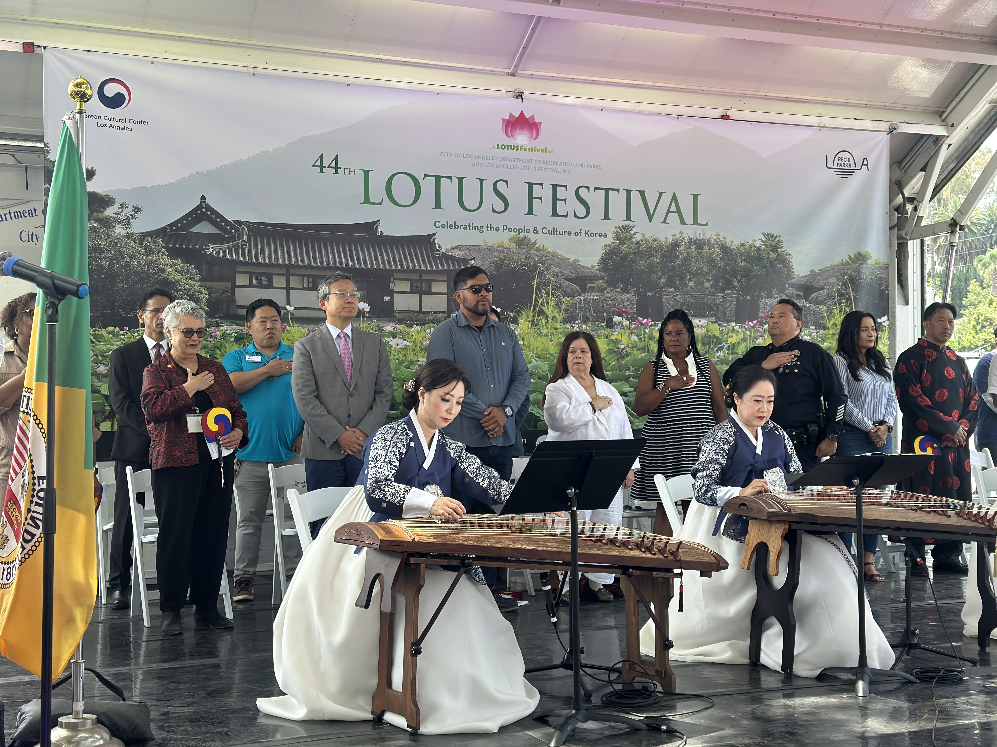 Los Angeles City Attorney Hydee Feldstein Soto and other dignitaries on stage, with their hands over their hearts, during the program of the 44th annual Lotus Festival.