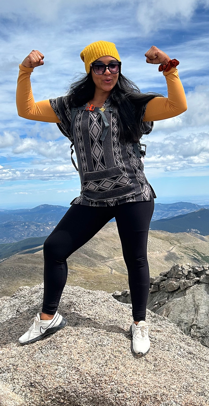 Sarah Davis stands tall and proud with Colorado mountains in the distance behind her.