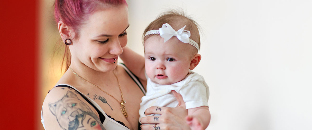 Smiling adult holding baby.