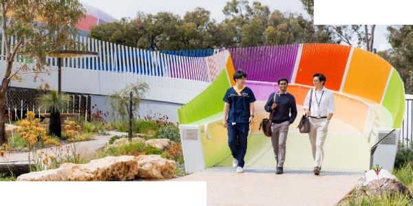 Three medical students walking along The Kids Bridge