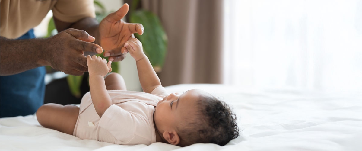 Baby holding adult's fingers