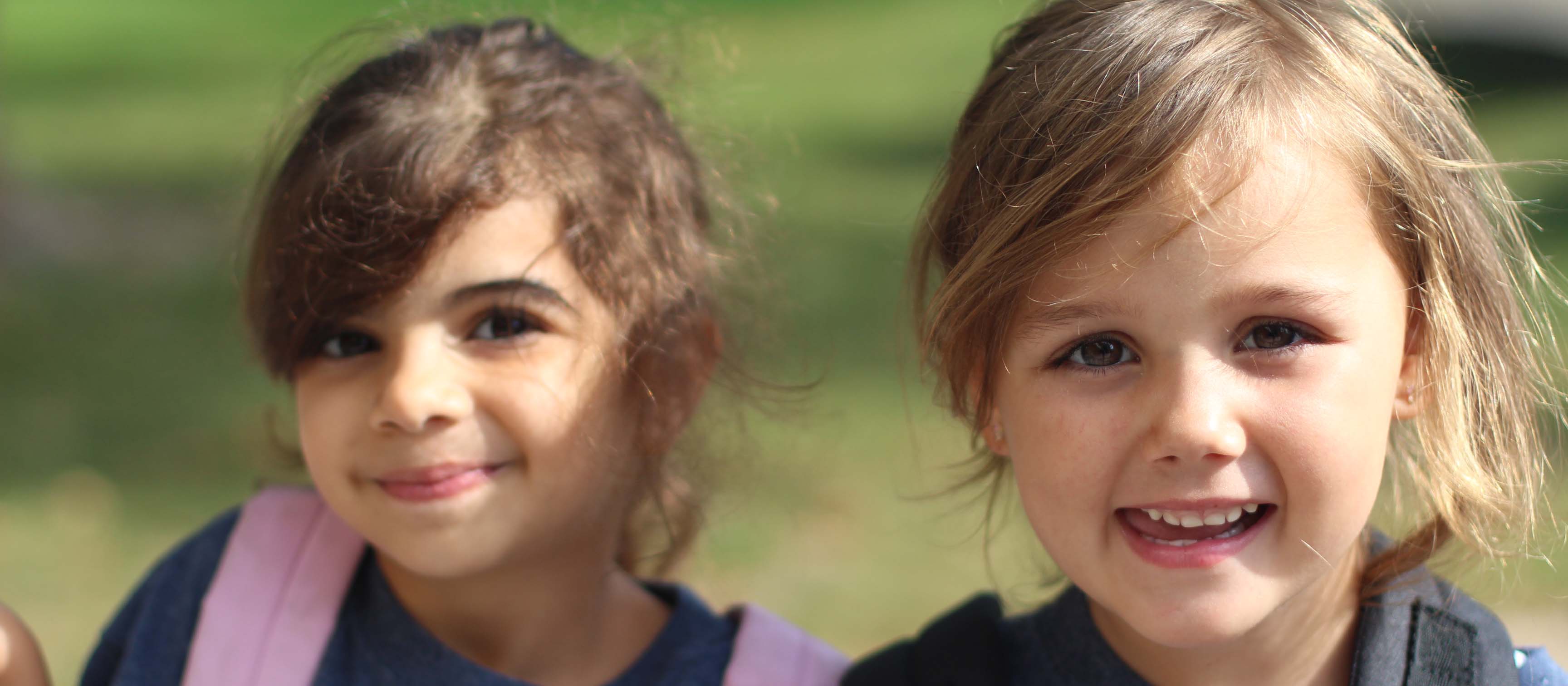 two kinder girls outside smiling