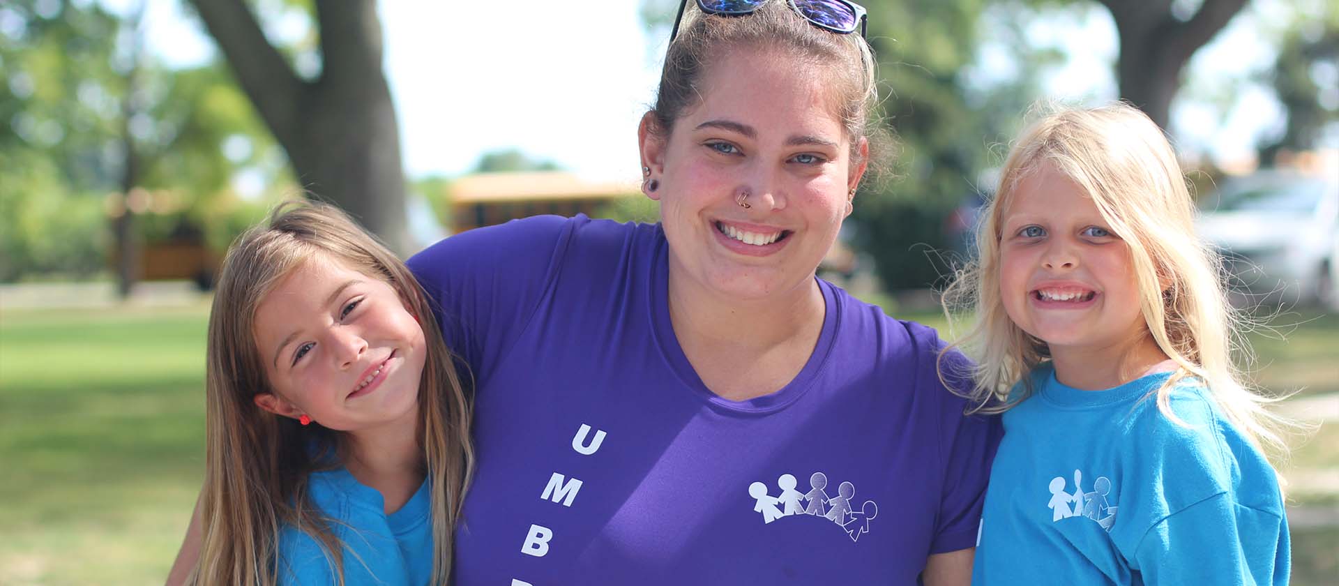 educator with two kinders outside