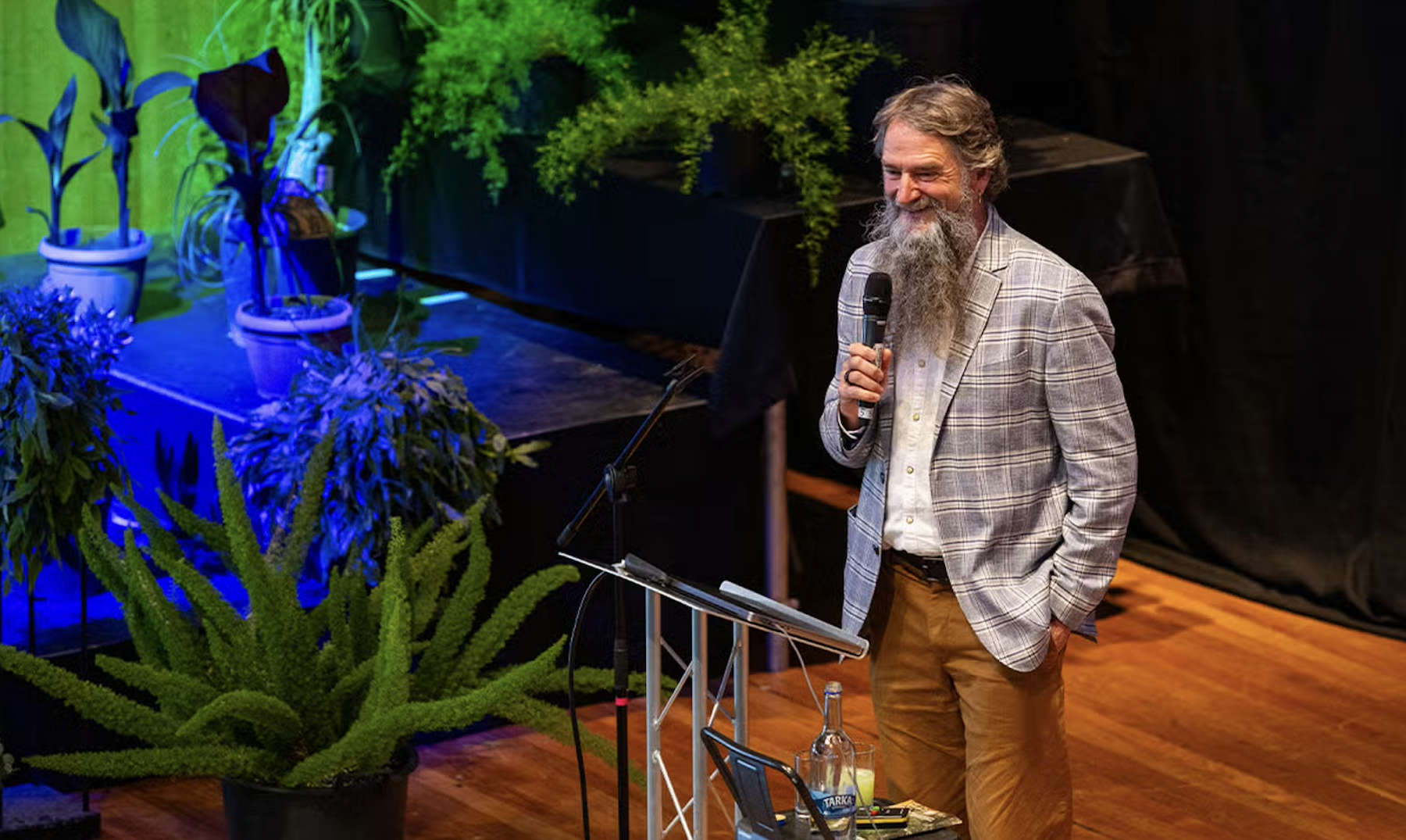 Biochemistry researcher Bruce Damer speaking on a stage.