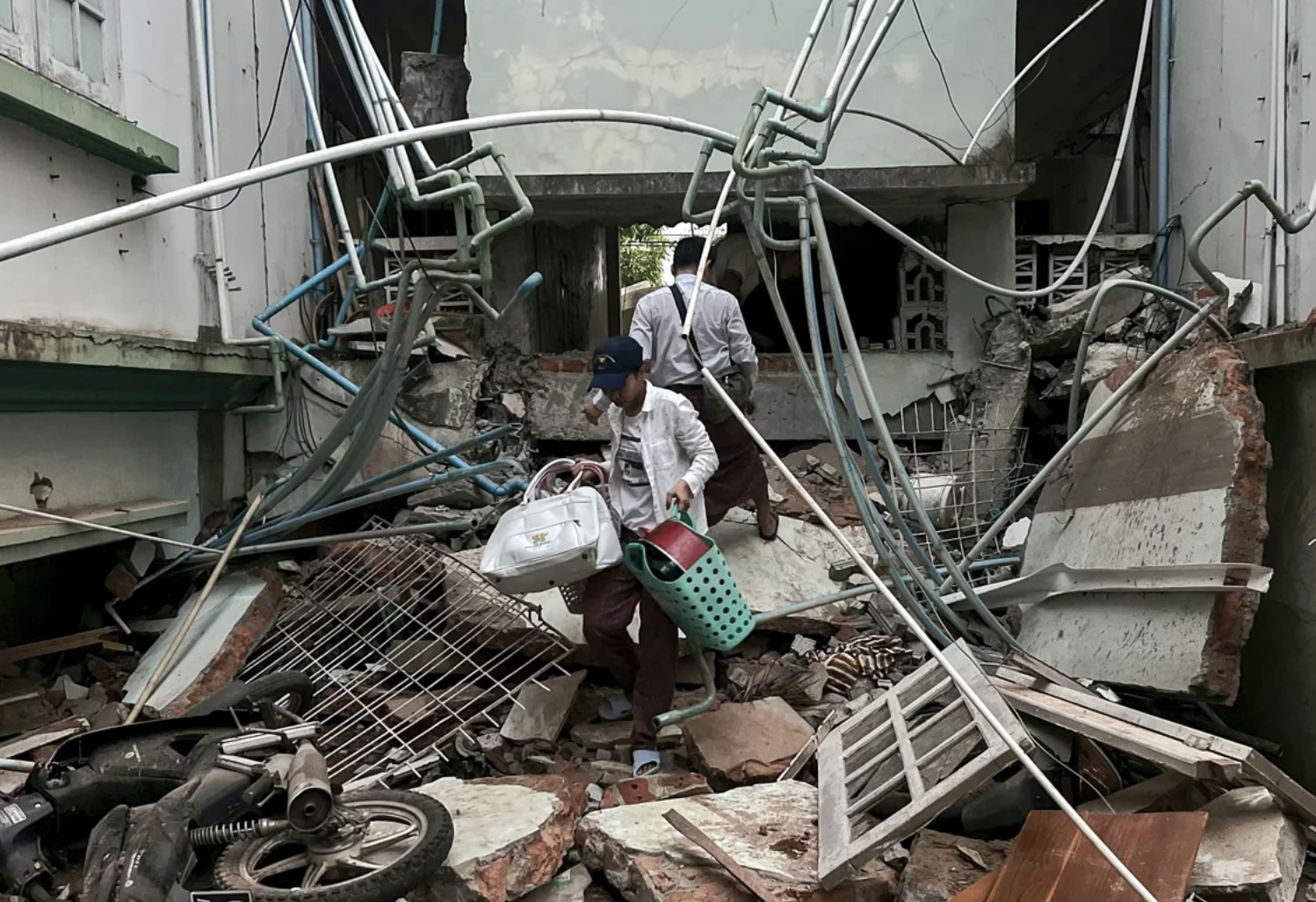Resident carrying belongings out of a building damaged by an earthquake