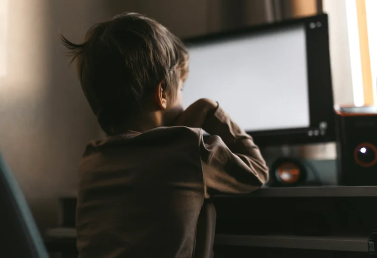 Little boy sits at a computer, online training during quarantine, distance learning