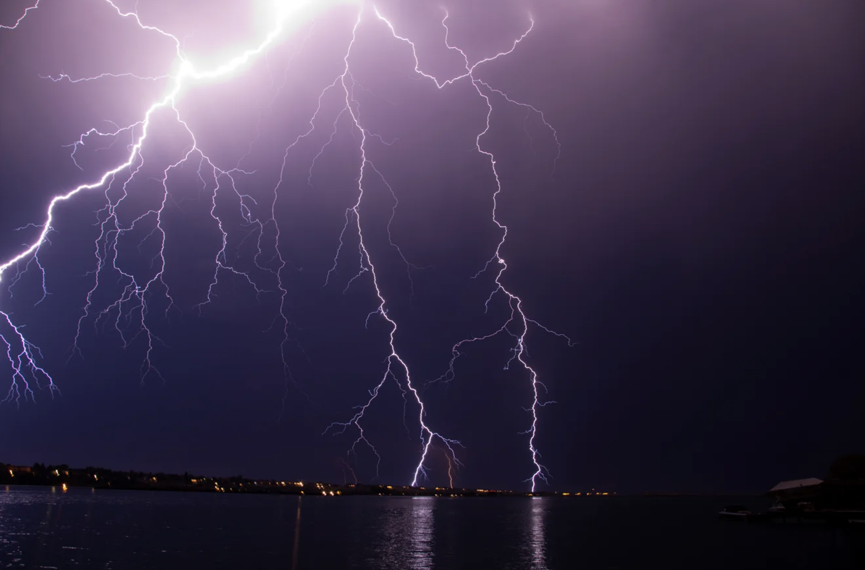 A web of lightning cracks across a purple night sky.