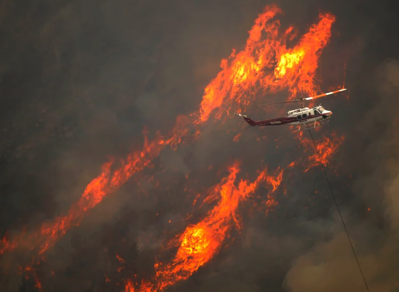A helicopter flew through the Cache La Poudre Canyon as flames scored the forest south of the river.