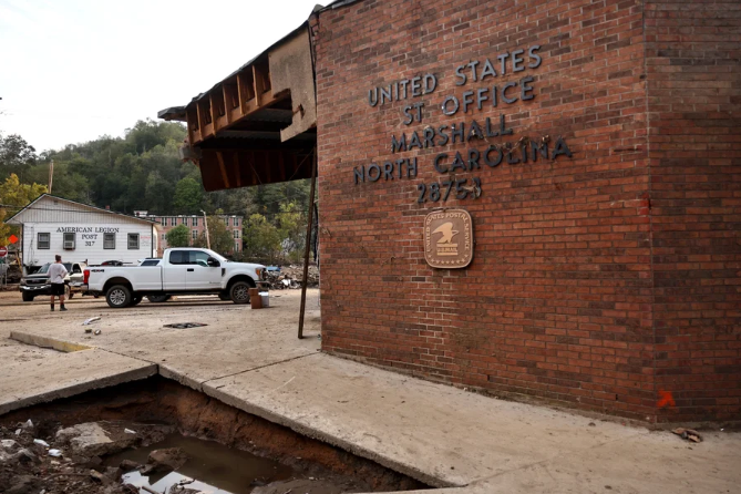 Top Story Image showing US Post Office damaged by flooding from Hurricane Helene, with collapsed sidewalk in front of building exterior