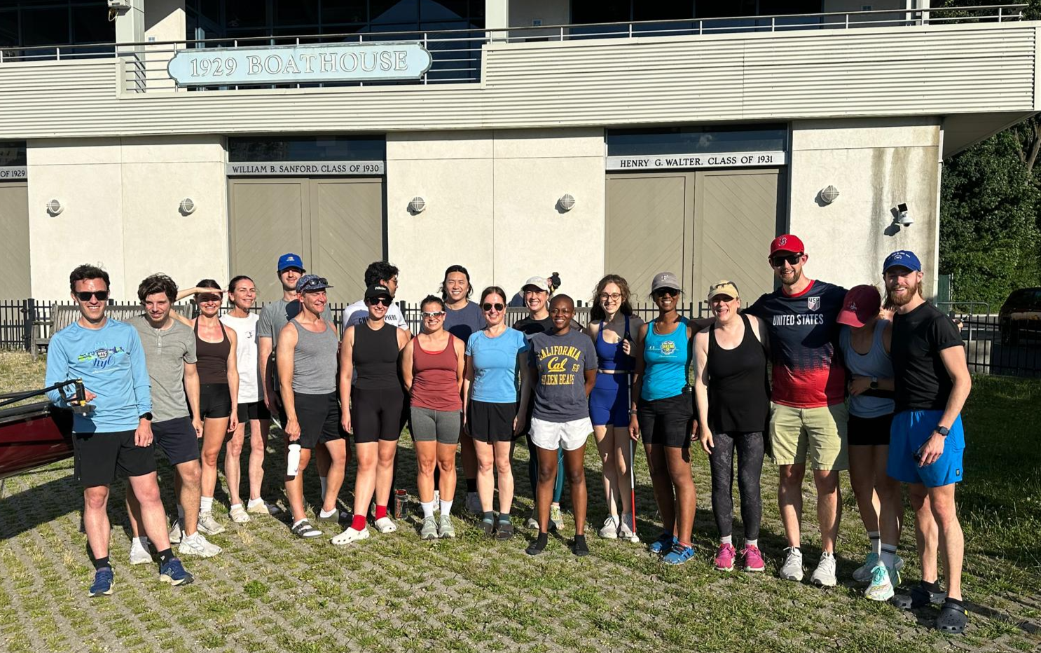 Eighteen people standing on front of the Columbia University boathouse