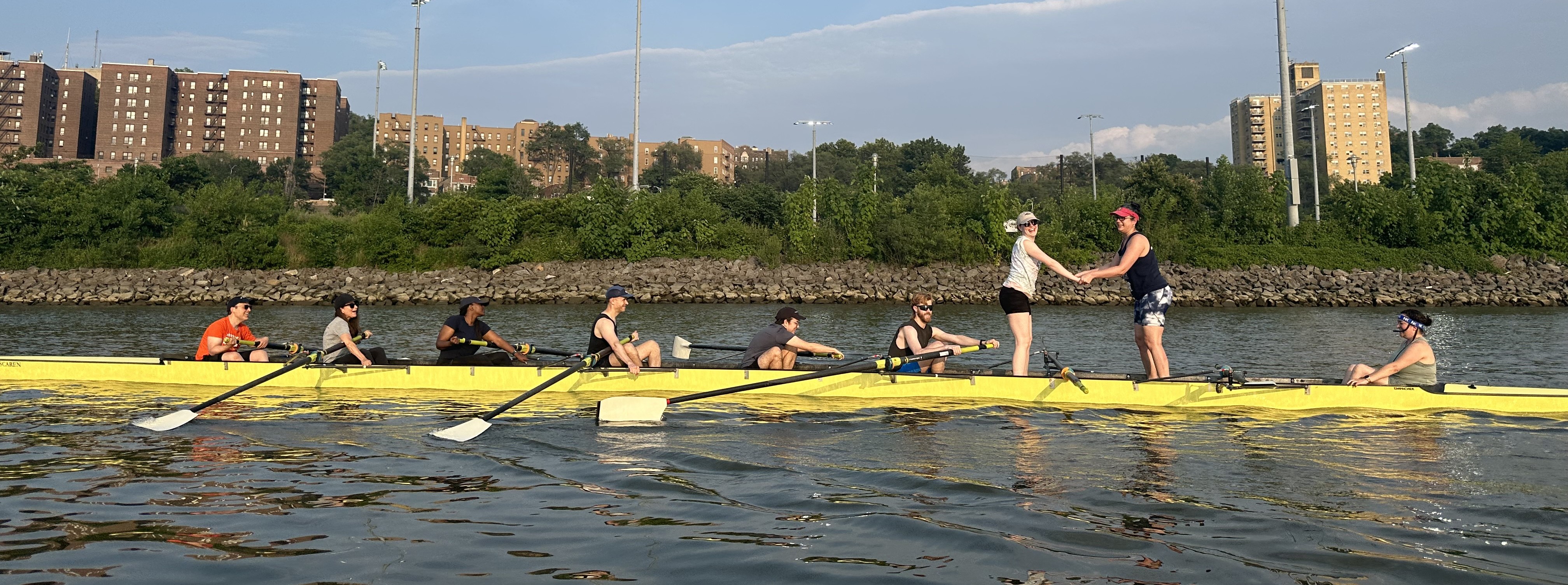 Eight person boat on the Harlem River. Stern pair are standing up in the boat as five and six seat row.