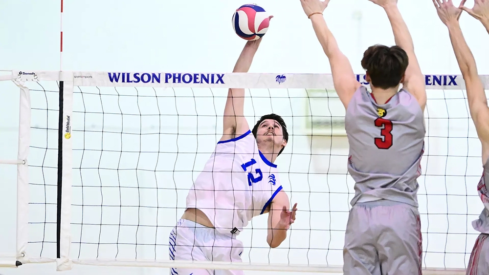 Two male volleyball players at the net