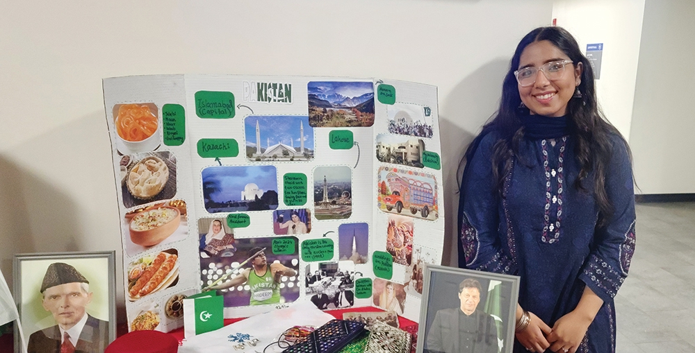 Student posing with a poster display