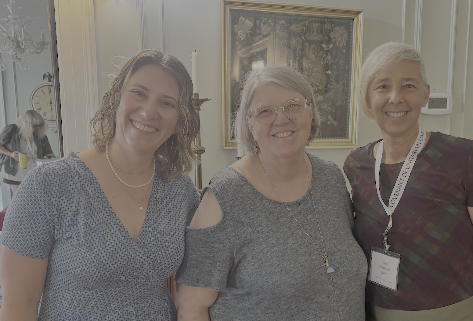 From left to right: Rev. Danielle (CUUPS), Jerri (CUUPS), and wren (NER) stand smiling together in a room.
