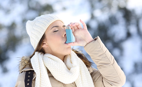 Young woman using inhaler